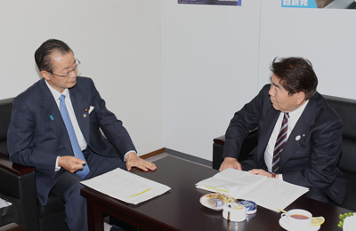 河村自民党地方創生実行統合本部長（左）に提言内容の実現を訴える藤原会長（右）の写真