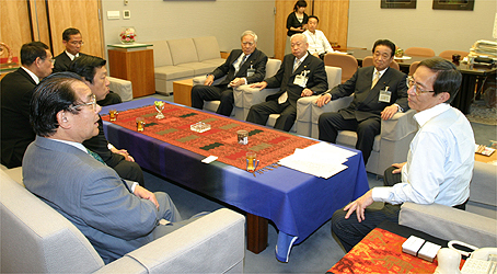 山本会長（中央奥）・細田内閣官房長官（右）の写真