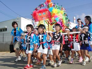 豊年祭（ハッピ鉢巻姿で神輿をかつぎ豊年を願う）の写真