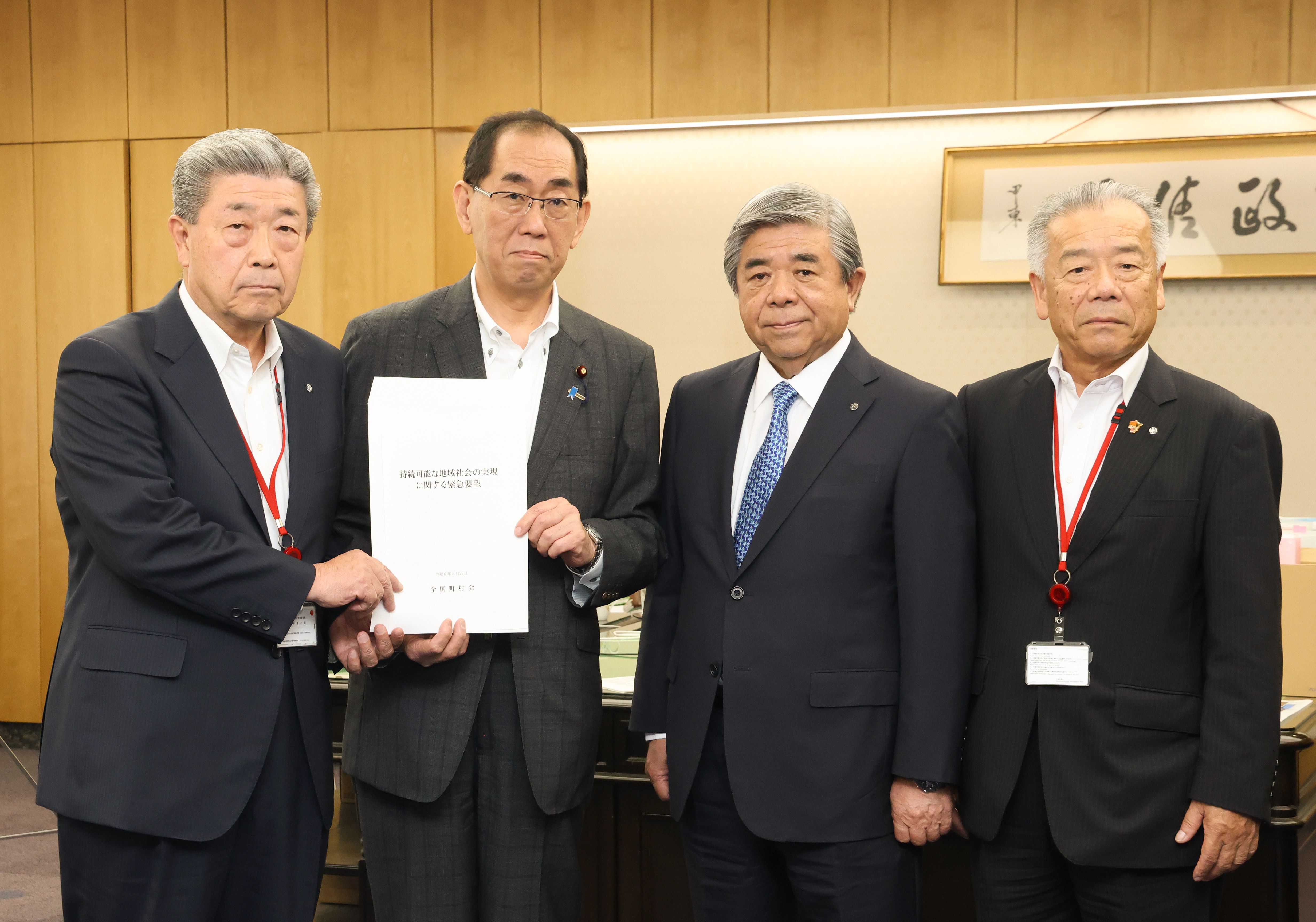 写真左から吉田会長、松本総務大臣、棚野会長代行、田島会長代行