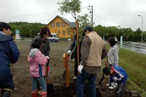 完成住宅と家族で記念植樹の様子の写真