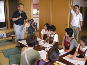 金丸弘美先生の話を熱心に聞く山の駅従業員の写真