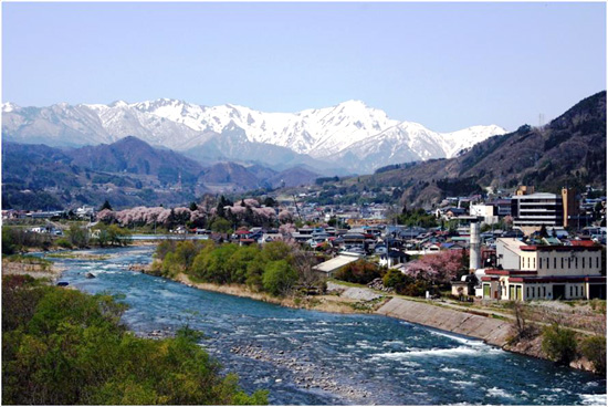 町の中心を流れる利根川と雄大な谷川岳の様子の写真