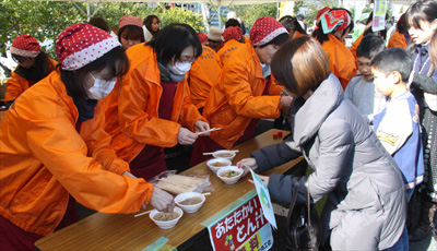 歓迎セレモニーで豚汁をふるまう地元婦人会の様子の写真