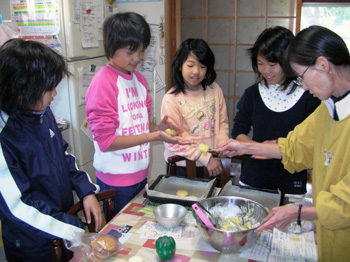 民泊先のお母さんに郷土料理を習う子どもたちの写真