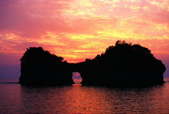 円月島に沈む夕日の写真