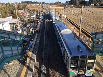 電車を見送る地域住民の写真