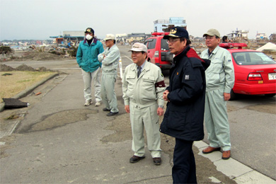 亘理町の被害状況の説明を受ける藤原会長（中央）、佐々木理事（右）（右から2人目は齋藤邦雄・亘理町長）の写真