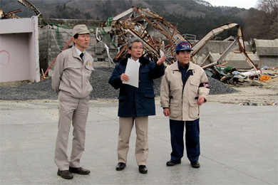 山田町で沼崎町長（中央）から被災現場の説明を受ける藤原会長（右）、稲葉理事（左）
