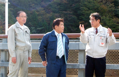 更谷村長（右）から被災状況について説明を受ける藤原会長（中央）小城理事（左）