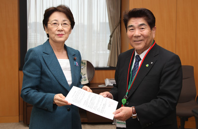 山谷大臣（左）に要望書を手渡す藤原会長（右）の写真