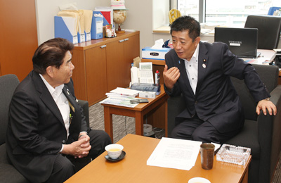 井原巧　自民党総務部会副会長(右)に要請する藤原会長（左）の写真