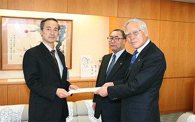 左より辻厚生労働審議官・小野監事・山本会長の写真